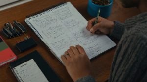 hombre tomando notas en un cuaderno de manera ordenada